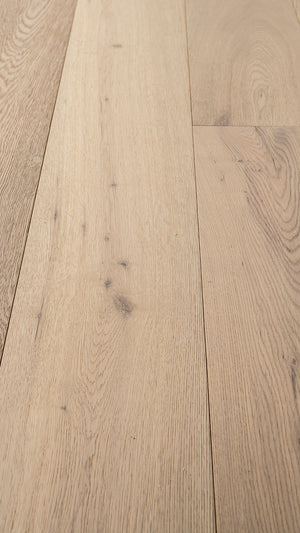 A picture of the oak  hardwood flooring called Dublin from the Wildwood Antique Collection, showing some minor knots and variation with a light, white-washed hue and beige tones.