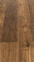 A picture showing the oak hardwood called Geneva from the Wildwood Nature Collection. The hardwood is a brown-amber colour, with some areas of darker tones and some with lighter tones. The floor is lightly hand scrapped and has a beautiful, rustic look, reminiscent of flooring found in old european castles.