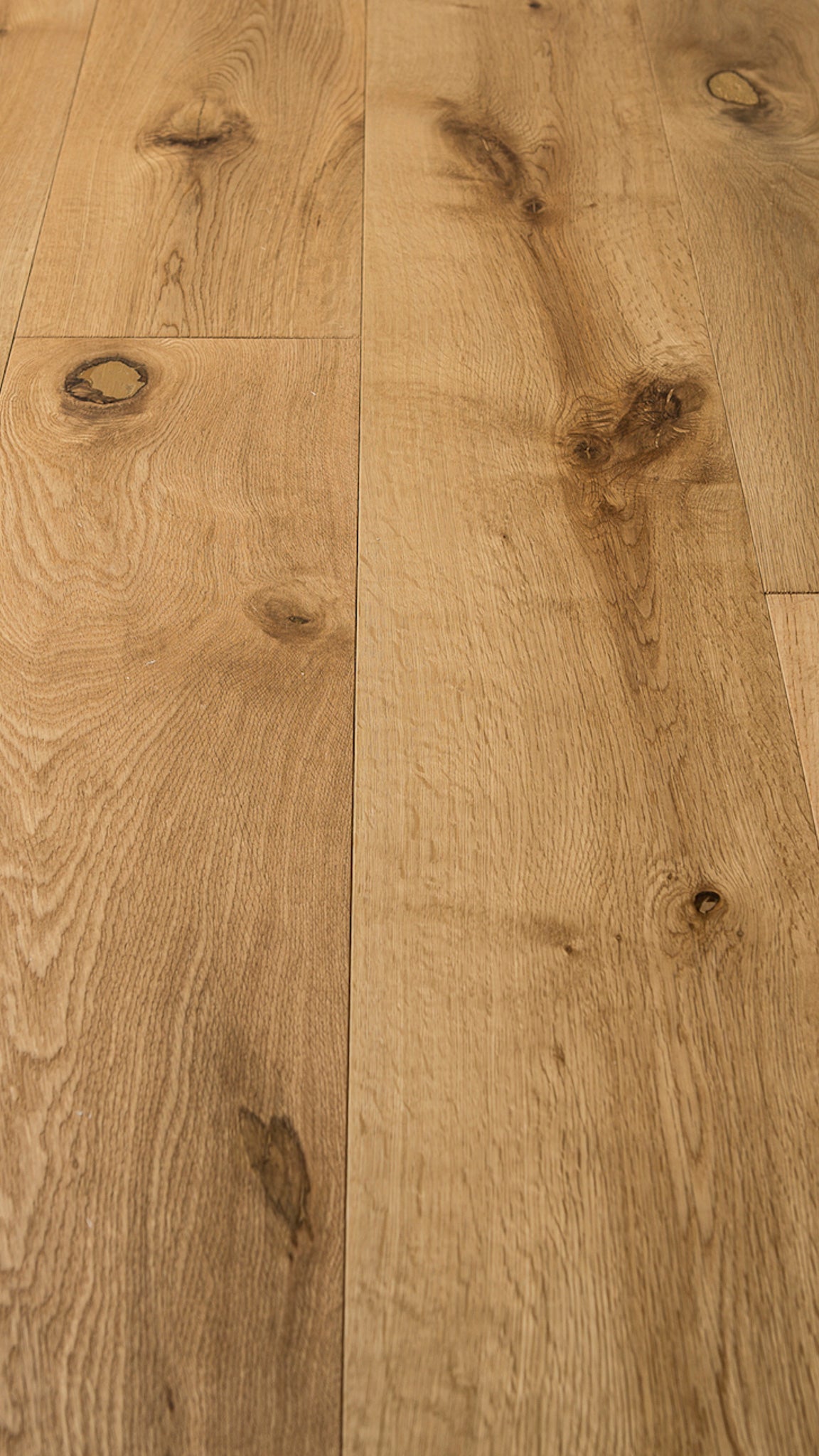 A picture of the oak  hardwood flooring called Oak Natural from the Wildwood Antique Collection, showing some knots and variation with a light amber tone.