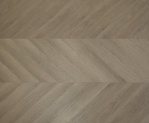 A picture showing the 6.5mm lvp flooring called Saigon in the chevron pattern. This vinyl floor is uniquely crafted and can only be installed in the chevron pattern. It has a light medium beige hue and silver chain embossing, giving the floor an ultra-realistic look.