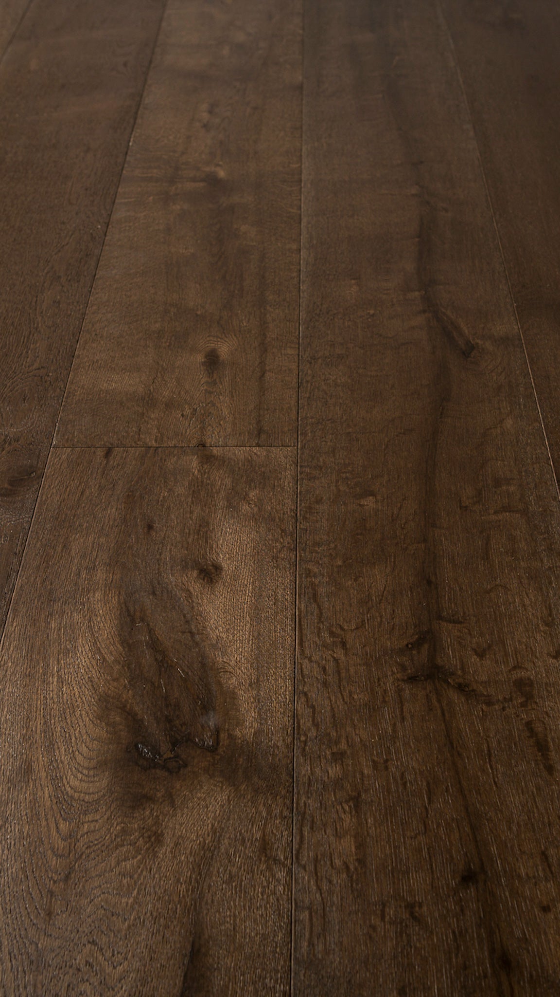 A picture of the oak  hardwood flooring called Vienna from the Wildwood Antique Collection, showing some knots and variation with a dark brown stain.