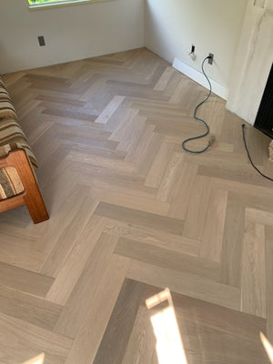 A picture showing Arvand herringbone installed in the hallway of a home. The hardwood is very clean looking and shows no knots, a quality of the high grade of hardwood used.