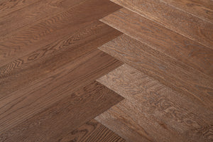 A photo showing the hardwood Como from the Wildwood Nature Herringbone Collection. This hardwood is dark brown stained and the high grade of wood means minimal knots and variation from board to board.