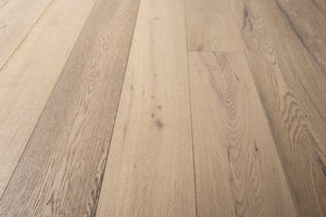 A picture of the oak  hardwood flooring called Dublin from the Wildwood Antique Collection, showing some minor knots and variation with a light, white-washed hue and beige tones.