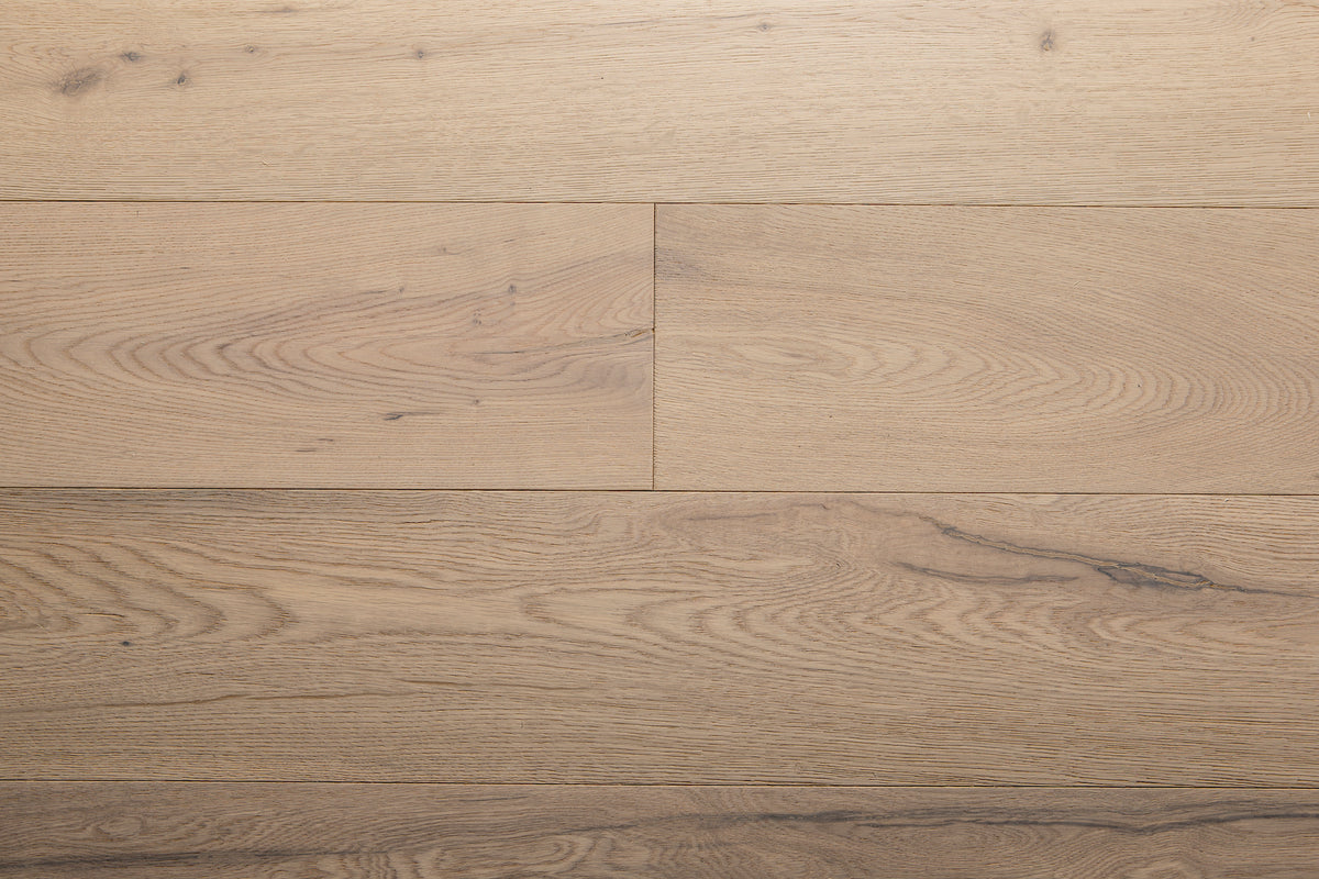 A picture of the oak  hardwood flooring called Dublin from the Wildwood Antique Collection, showing some minor knots and variation with a light, white-washed hue and beige tones.