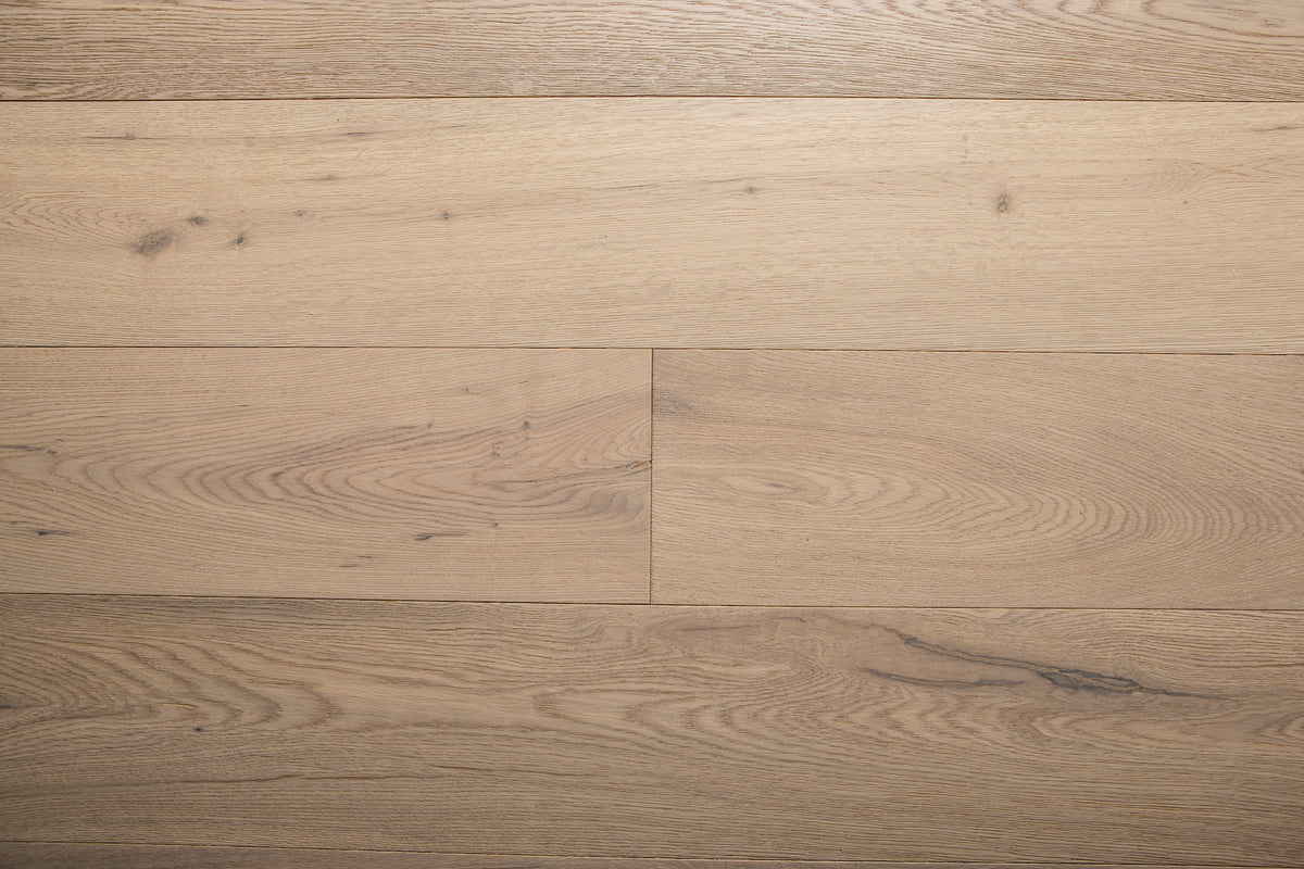 A picture of the oak  hardwood flooring called Dublin from the Wildwood Antique Collection, showing some minor knots and variation with a light, white-washed hue and beige tones.