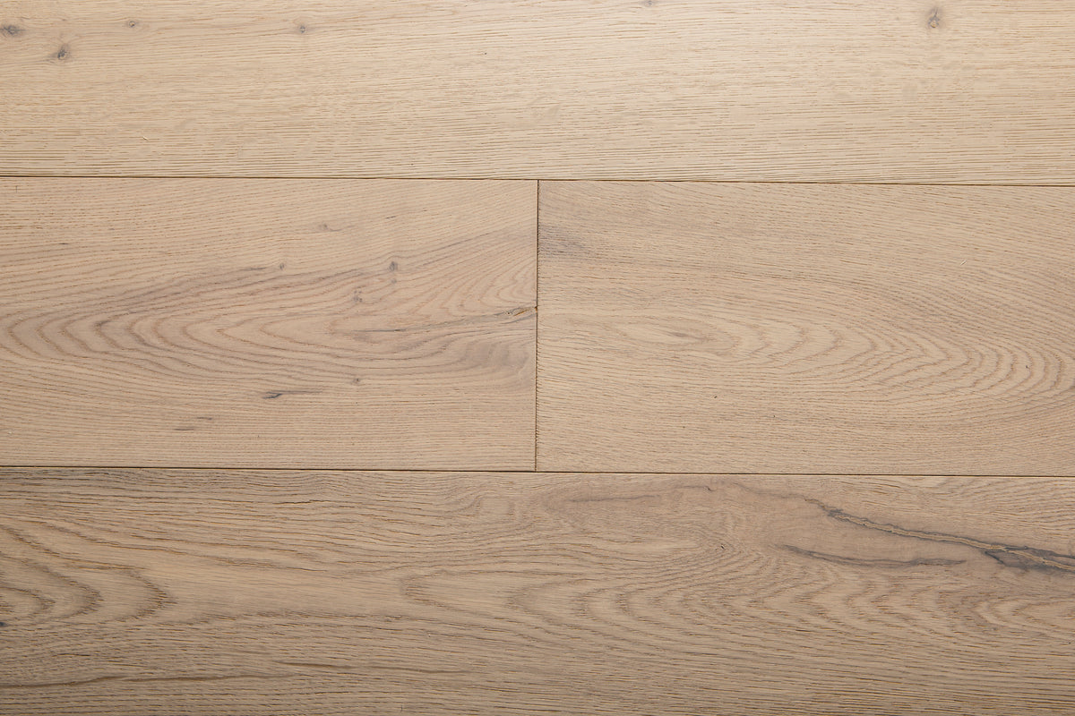 A picture of the oak  hardwood flooring called Dublin from the Wildwood Antique Collection, showing some minor knots and variation with a light, white-washed hue and beige tones.