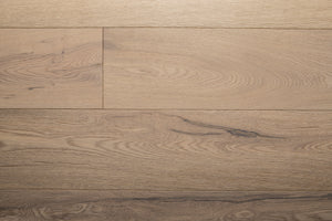 A picture of the oak  hardwood flooring called Dublin from the Wildwood Antique Collection, showing some minor knots and variation with a light, white-washed hue and beige tones.