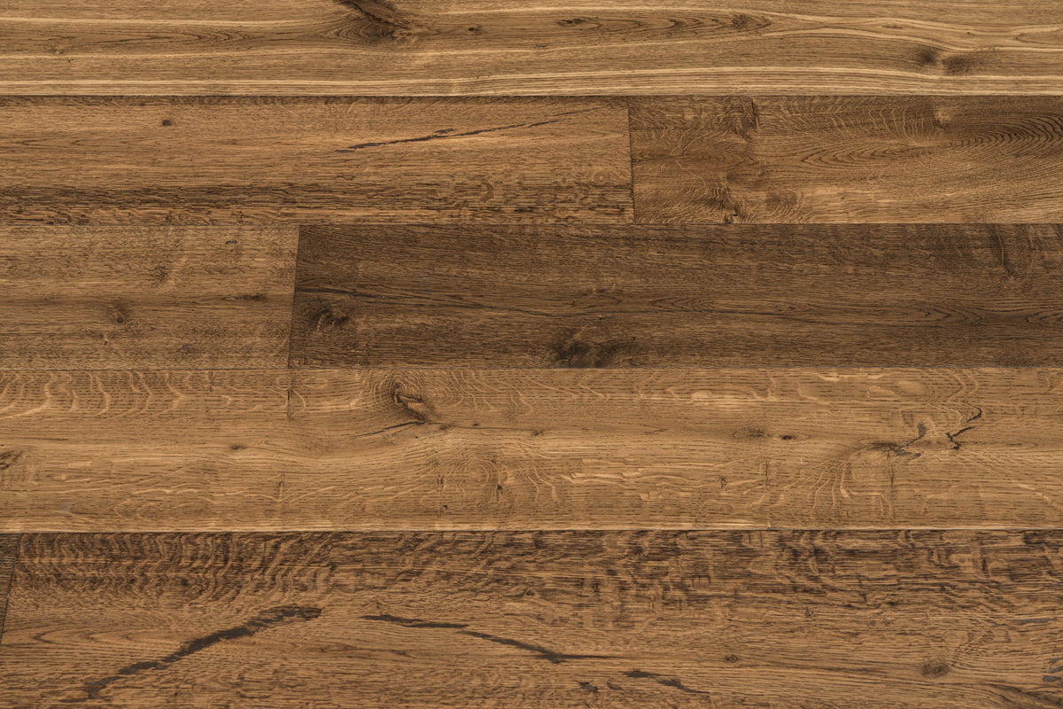 A picture showing the oak hardwood called Geneva from the Wildwood Nature Collection. The hardwood is a brown-amber colour, with some areas of darker tones and some with lighter tones. The floor is lightly hand scrapped and has a beautiful, rustic look, reminiscent of flooring found in old european castles.