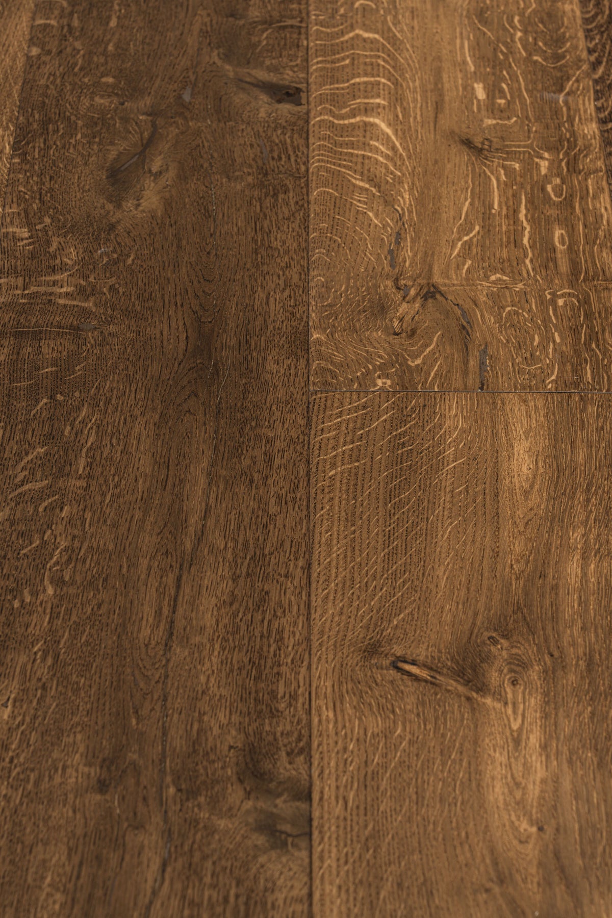 A picture showing the oak hardwood called Geneva from the Wildwood Nature Collection. The hardwood is a brown-amber colour, with some areas of darker tones and some with lighter tones. The floor is lightly hand scrapped and has a beautiful, rustic look, reminiscent of flooring found in old european castles.