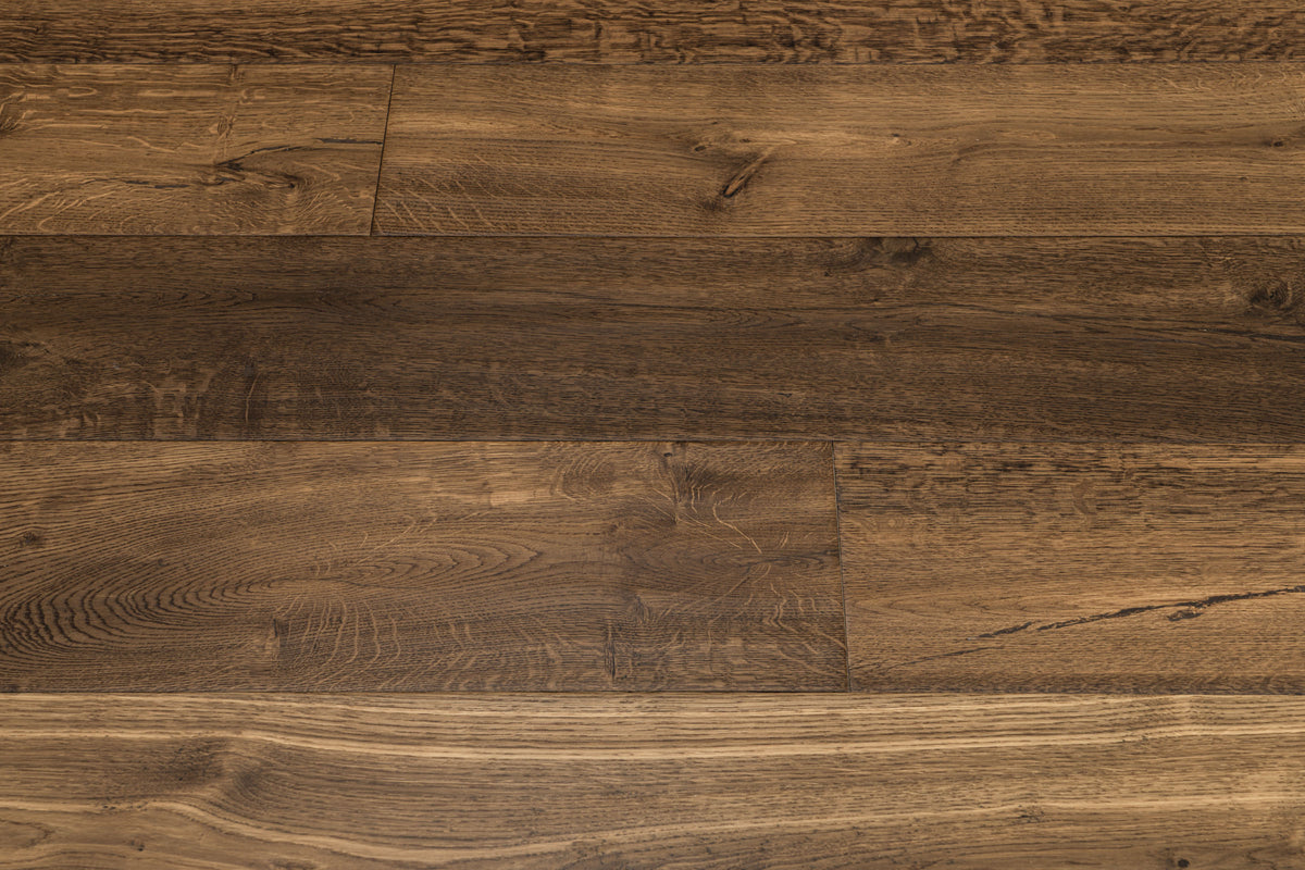 A picture showing the oak hardwood called Geneva from the Wildwood Nature Collection. The hardwood is a brown-amber colour, with some areas of darker tones and some with lighter tones. The floor is lightly hand scrapped and has a beautiful, rustic look, reminiscent of flooring found in old european castles.