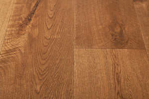 A picture of the oak  hardwood flooring called Oak Natural from the Wildwood Antique Collection, showing some knots and variation with a brown-red tone.