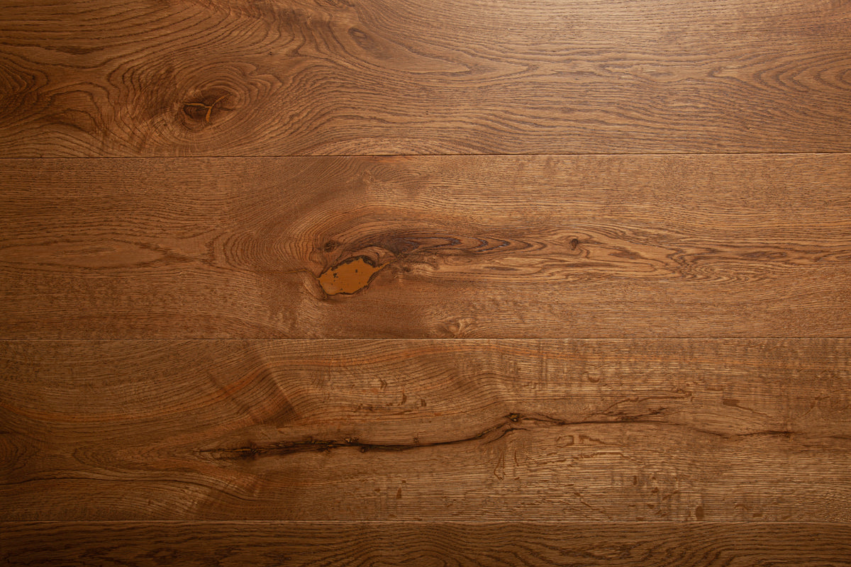 A picture of the oak  hardwood flooring called Oak Natural from the Wildwood Antique Collection, showing some knots and variation with a brown-red tone.
