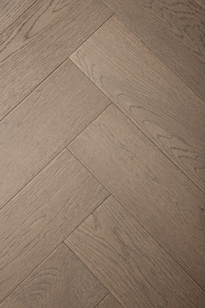 A photo of the hardwood called Milan in the herringone pattern. This oak hardwood features a muted grey stain and the high grade of the wood means there is minimal variation from board to board and little to no knots present.