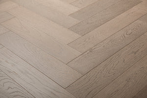 A photo of the hardwood called Milan in the herringone pattern. This oak hardwood features a muted grey stain and the high grade of the wood means there is minimal variation from board to board and little to no knots present.