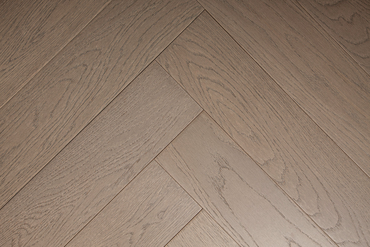 A photo of the hardwood called Milan in the herringone pattern. This oak hardwood features a muted grey stain and the high grade of the wood means there is minimal variation from board to board and little to no knots present.
