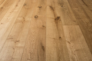 A picture of the oak  hardwood flooring called Oak Natural from the Wildwood Antique Collection, showing some knots and variation with a light amber tone.