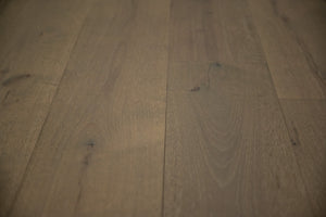 A picture of the oak  hardwood flooring called Oak Natural from the Wildwood Antique Collection, showing some knots and variation with a brown-gray tone.