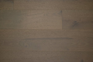 A picture of the oak  hardwood flooring called Oak Natural from the Wildwood Antique Collection, showing some knots and variation with a brown-gray tone.