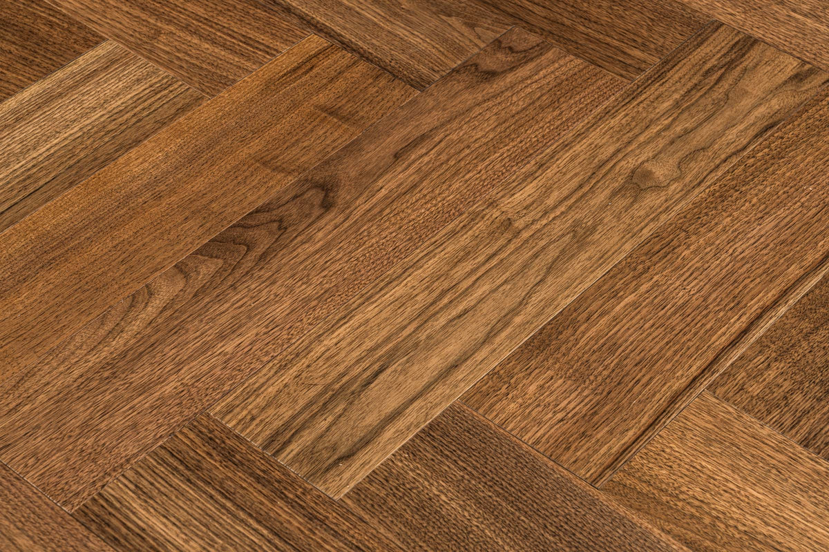 A picture of Walnut Natural Herringbone, from the Wildwood Nature Herringbone Collection. The hardwood is a warm brown walnut color, with some variation from board to board, characteristic of American Walnut.