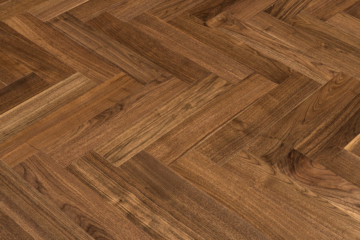 A picture of Walnut Natural Herringbone, from the Wildwood Nature Herringbone Collection. The hardwood is a warm brown walnut color, with some variation from board to board, characteristic of American Walnut.